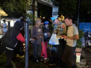 anggota polisi cimahi membagikan nasi bungkus kepada masyarakat saat patroli malam